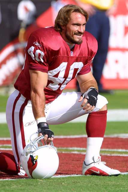 Pat Tillman kneeling and smiling before an NFL game