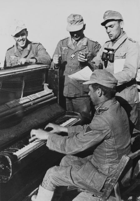 Soldiers standing around a piano