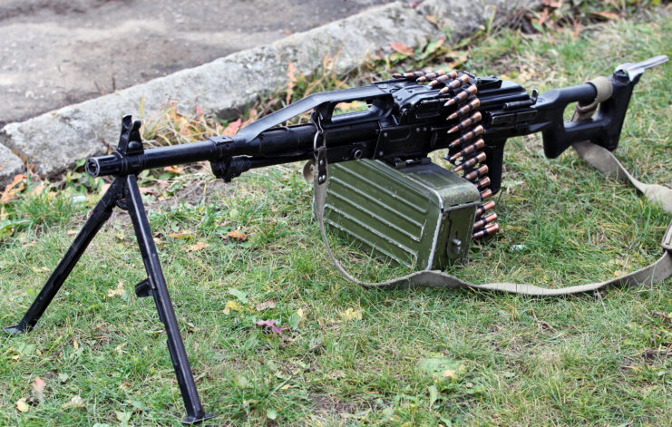 A PK-47 Machine gun mounted on a tripod with ammunition