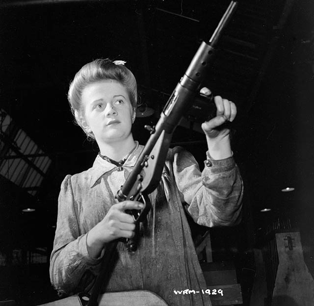 A factory worker posing with a STEN submachine gun