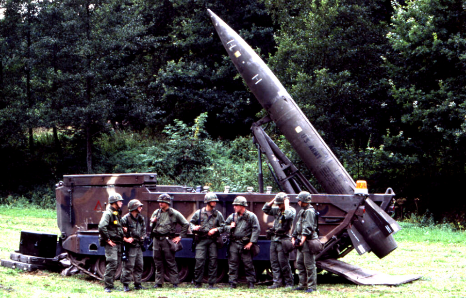 NATO members standing in front of a missile launcher
