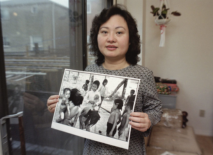 Phan Thị Kim Phúc holding a photograph from the Vietnam War