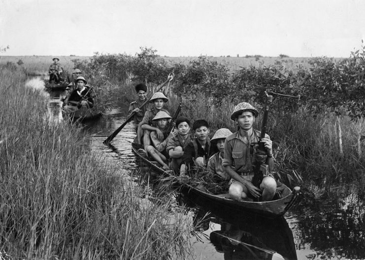 Communist guerillas sail in small boats during the Vietnam War