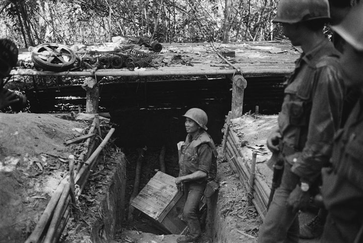 A solider stands in a bunker along the Ho Chi Minh Trail
