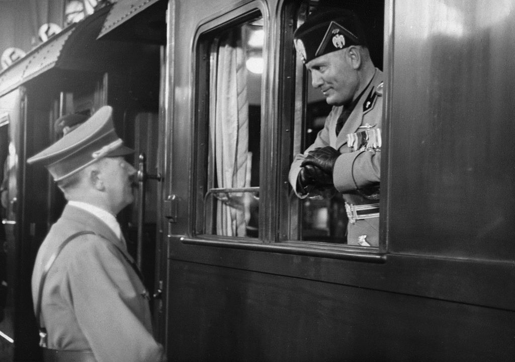 Benito Mussolini and Adolf Hitler have a conversation at a train station in 1937