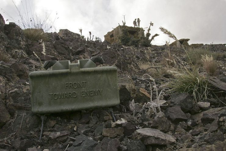 A Claymore mine placed on the ground, the front reads "Front Toward Enemy".