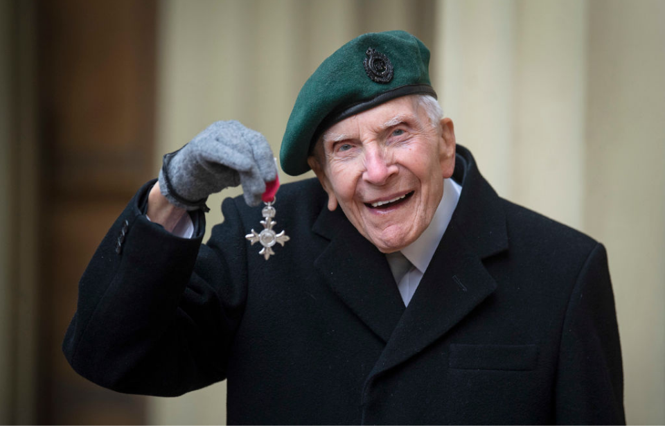 Horace 'Harry' Billinge holding up his MBE