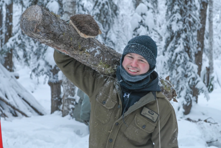 SERE Specialist holding a log