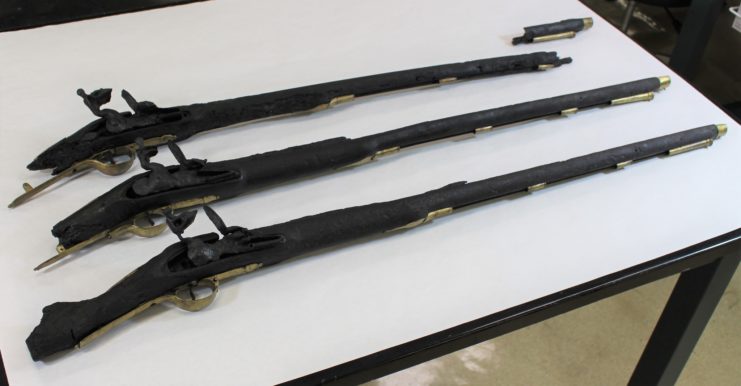 Three British Brown Bess muskets on a table