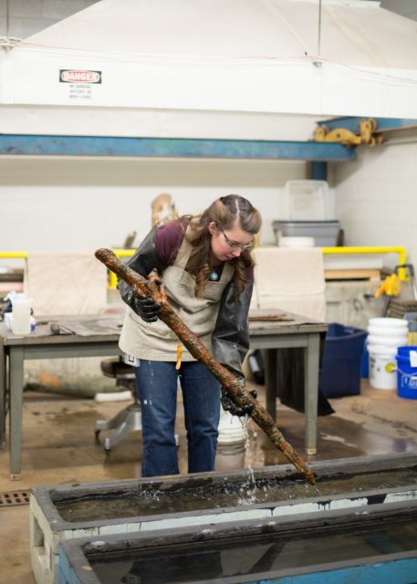 Conservator holding a British Brown Bess musket