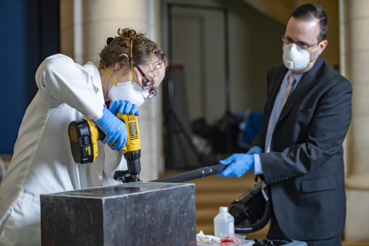 Conservator drilling into the Memorial Amphitheater time capsule