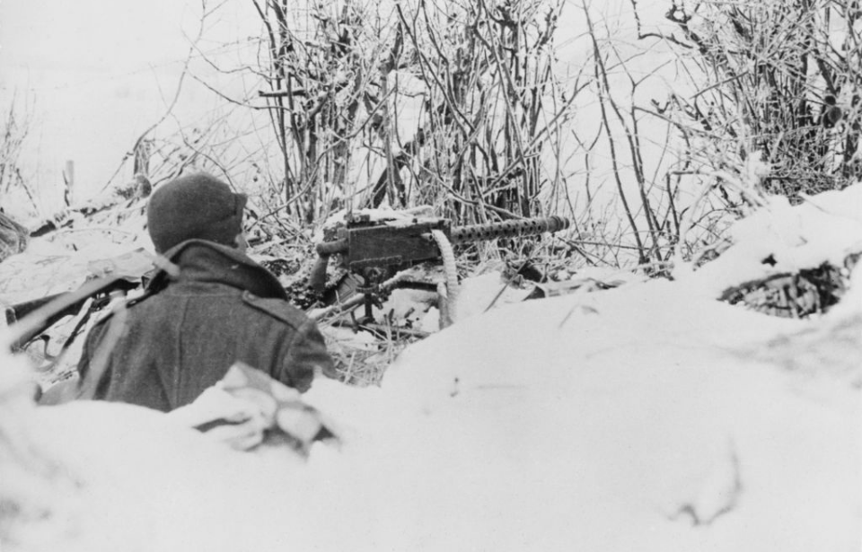 101st Airborne soldier aiming his weapon in the snow