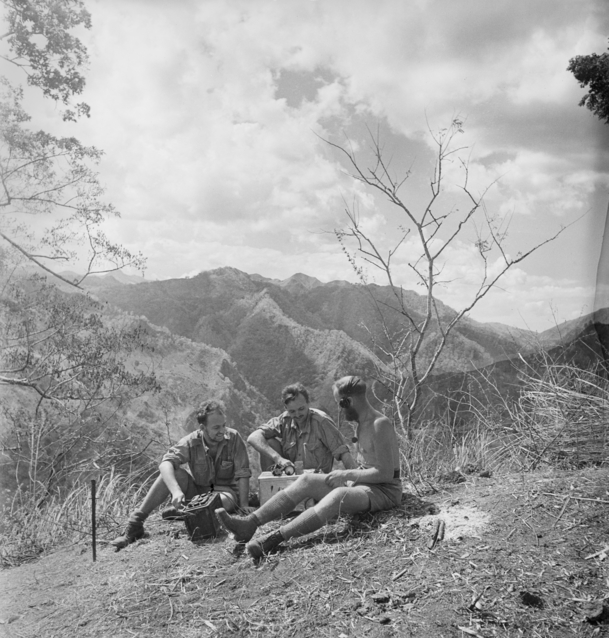 Three Australian commandos sitting around a radio