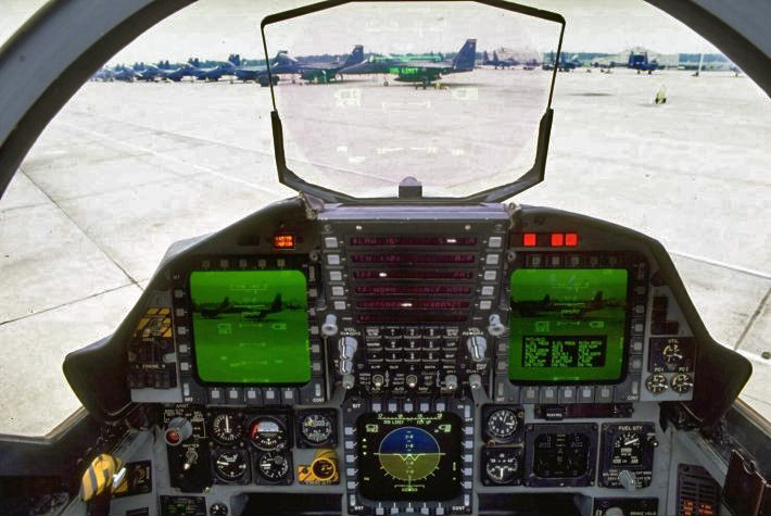 Cockpit of an F-15E Strike Eagle, with 2 monitors and a head-up display