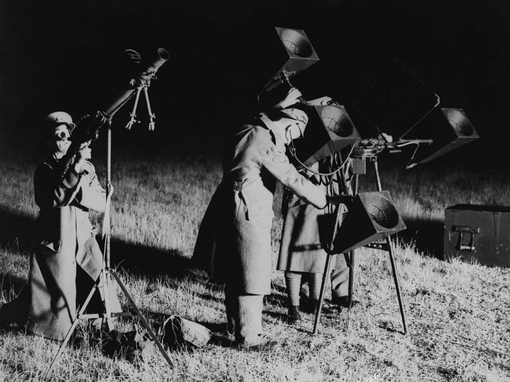 Three soldiers manning defense equipment at night
