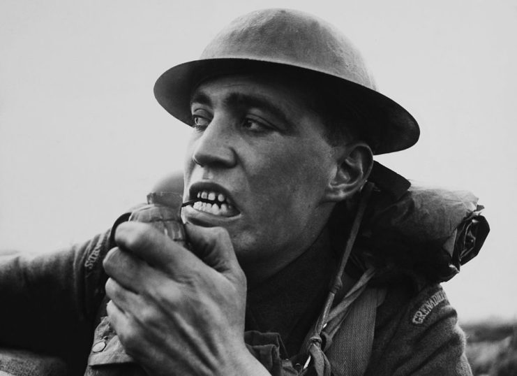 A soldier pulling a grenade pin out with his teeth