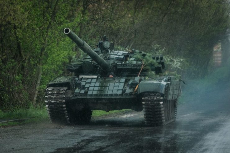 Ukrainian T-72 tank driving down a road