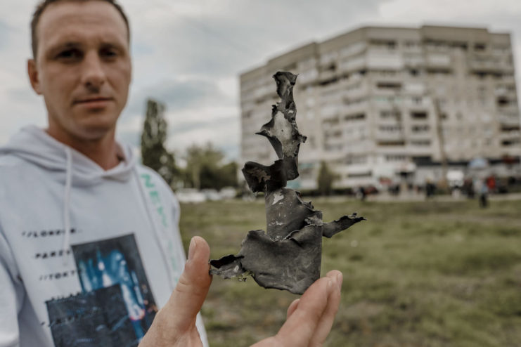 A man holding a piece of metal shrapnel