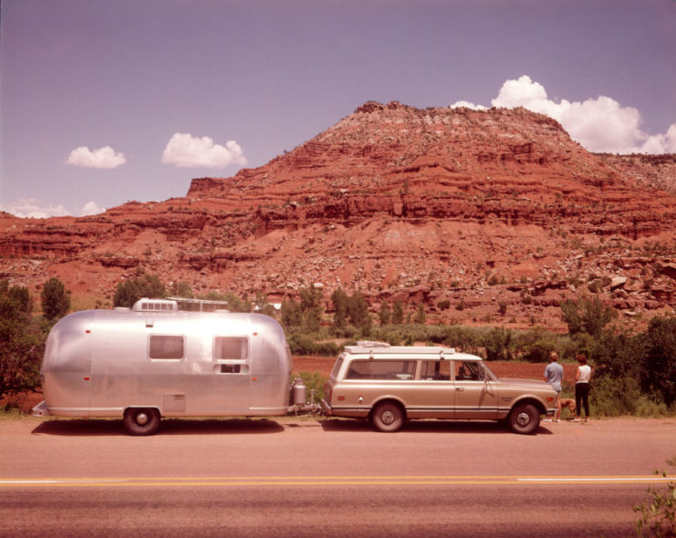 Couple standing outside their vehicle and Air Stream trailer