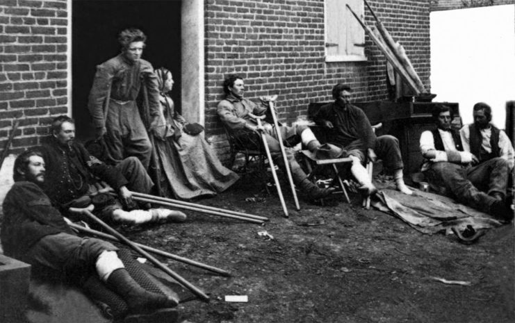 Wounded Civil War soldiers sitting outside a hospital