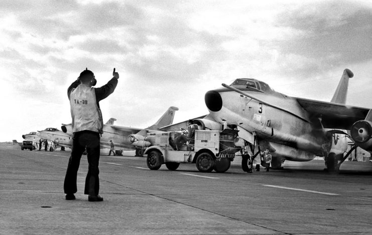 US Navy personnel directing aircraft on the runway