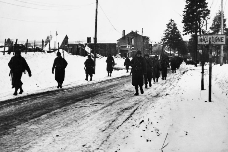 Soldiers marching along a road in the snow
