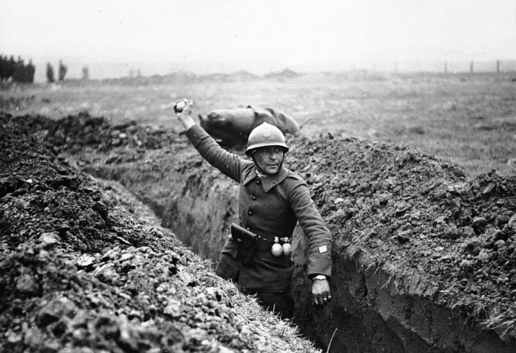 Soldier throwing a grenade from a trench