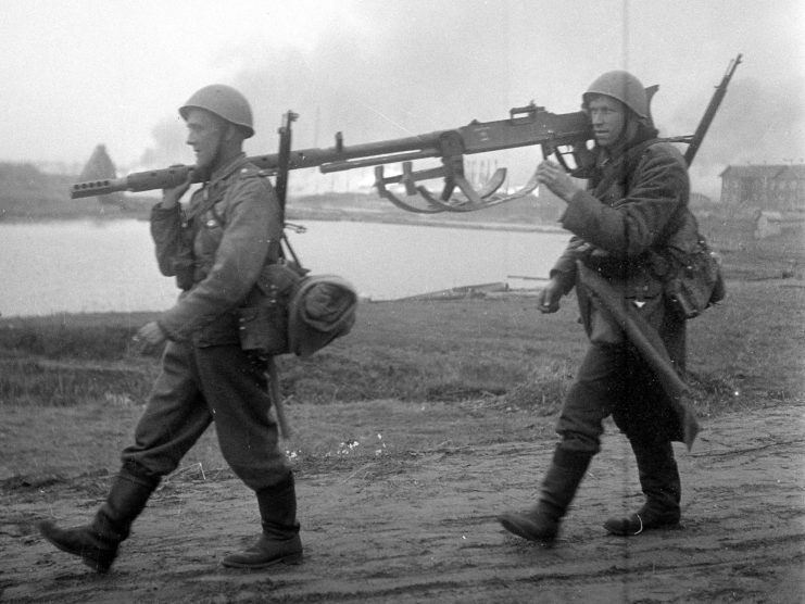 Two Finnish soldiers carrying the barrel of a Lahti L-39