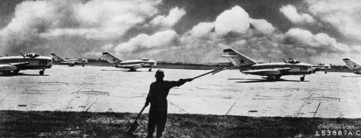 Man waving flags at Mikoyan-Gurevich MiG-15s