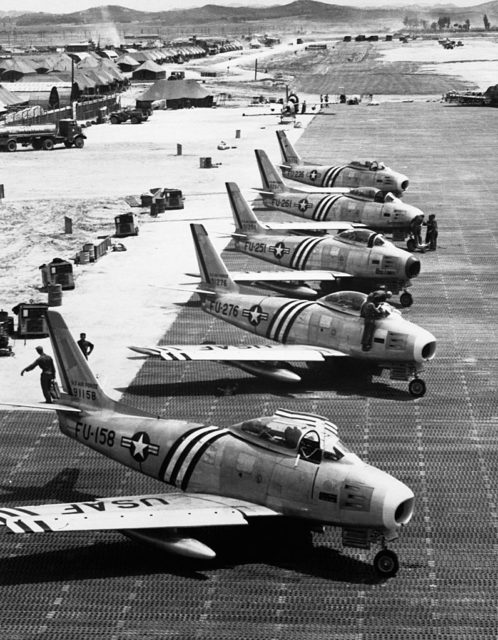 Row of North American F-86 Sabres parked on a runway