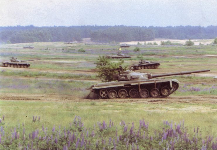 Three Polish T-72 tanks traveling through a field