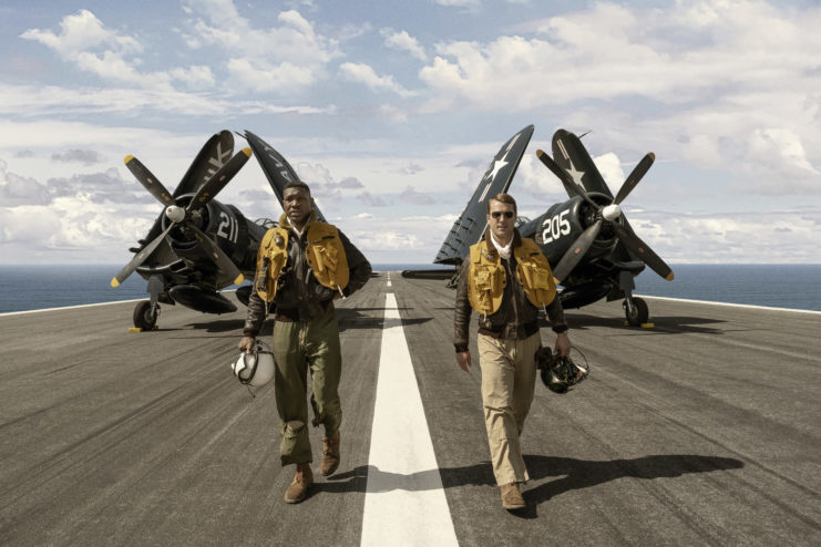 Characters Jesse Brown and Glen Powell on the landing strip of a aircraft carrier.