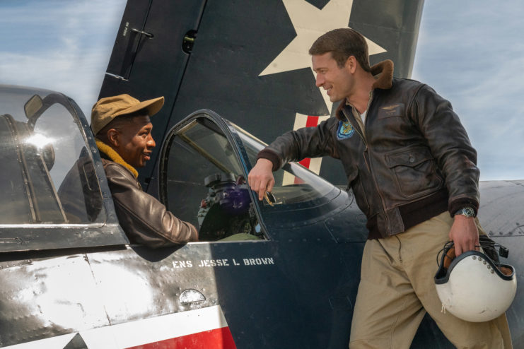 Tom Hudner (Glen Powell) and Jesse Brown (Jonathan Majors) talk while Brown sits in the cockpit of his plane.