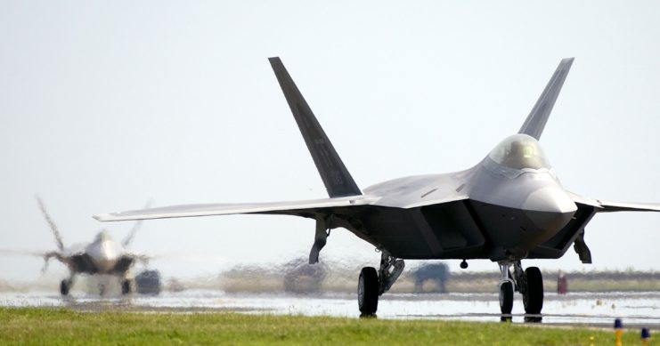 Two Lockheed Martin F-22 Raptors taxiing down a runway