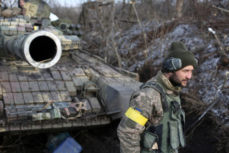 Chechen fighter standing in front of a tank