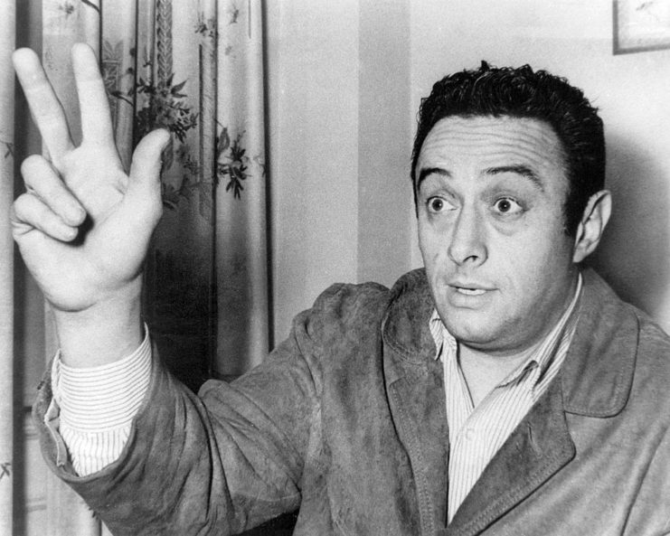 Lenny Bruce holding up his hand