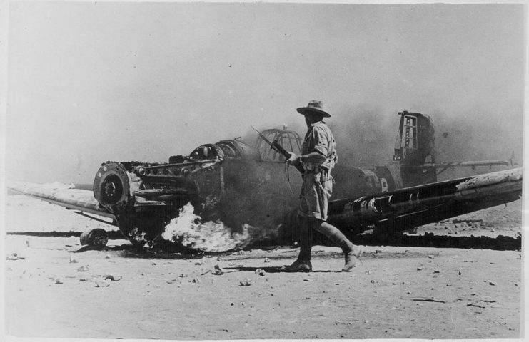 Allied soldier walking by a downed German bomber