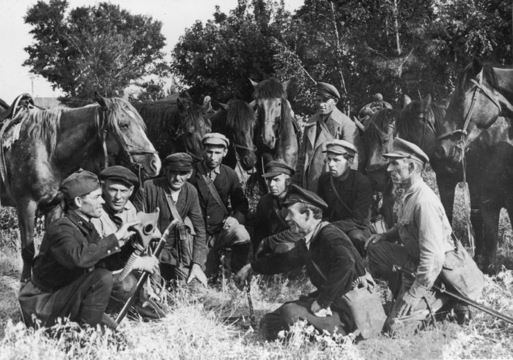 Russian Cossacks crouched in front of their horses