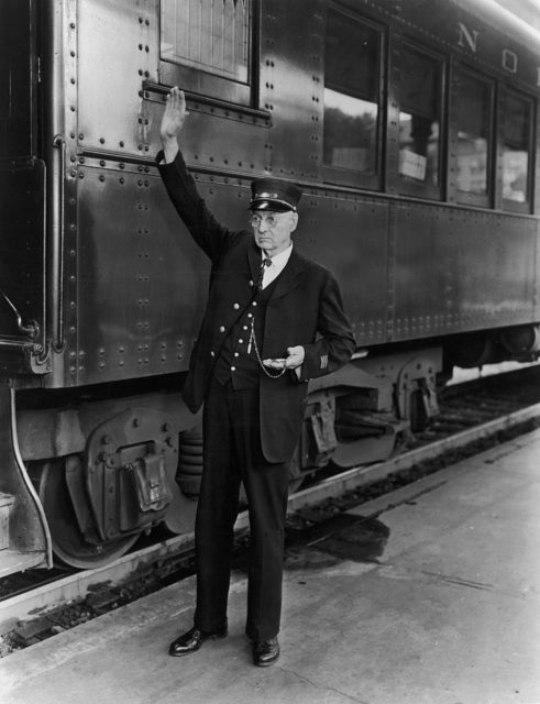 Train conductor holding his hand above his head