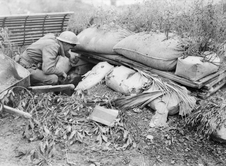 Canadian soldier inspecting a German machine gun nest