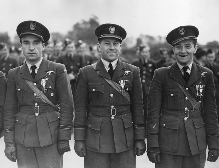 Three pilots with the No. 303 Squadron standing together in uniform