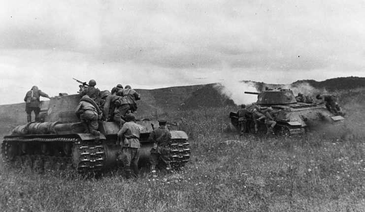 Soviet infantrymen sheltering behind T-34 tanks