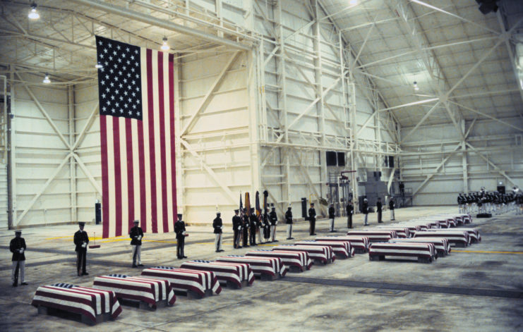 Coffins wrapped in the American flag lay in front of US Honor Guardsmen