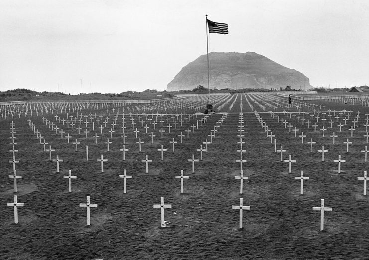 Rows of crosses watched over by the American flag