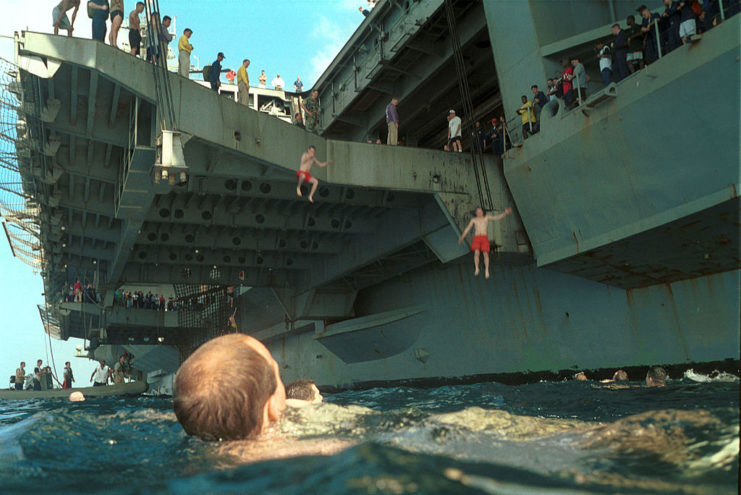 Crew members jumping off the deck of the USS Kitty Hawk (CV-63)