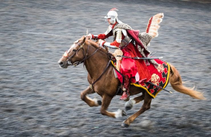 Winged hussars cavalryman riding on the back of a horse