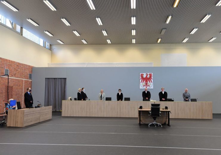 Court officials standing and sitting at their desks