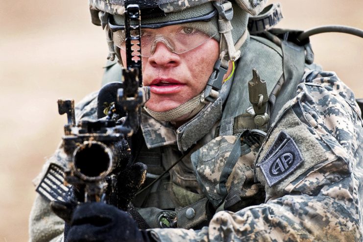 Spc. Travis Williams aiming an M320 grenade launcher