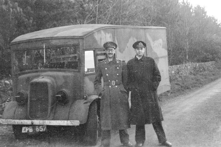 Charles Cholmondeley and Ewen Montagu standing in front of a truck