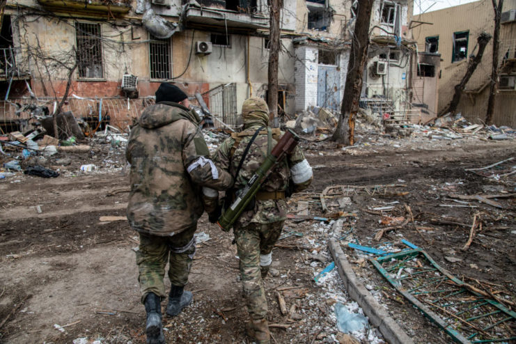 Chechen and Russian soldiers walking through a damaged street